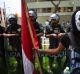 A protester in mask holds a Peruvian national flag during a rally against the Trans Pacific Partnership in Lima, Peru in ...