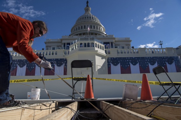 A worker pulls a cable line from the floor of the inaugural platform on the west front of the US Capitol in Washington, DC.