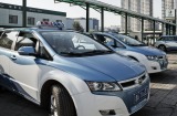 BYD Co. E6 electric taxis stand while being charged at a State Grid Corp. of China charging station in Taiyuan, Shanxi ...