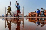 Children chasing a kite in front of the 17th century Jama Masjid mosque, in Old Delhi. 