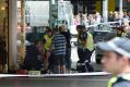 Ambulance paramedics treat an injured pedestrian on Bourke Street.