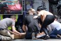 People help the injured after a car ploughed through pedestrians in Bourke Street.