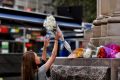 Passers-by lay flowers at the scene of yesterday's Bourke Street Mall tragedy.