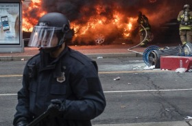 Police respond as protesters burn a limousine during demonstrations against the inauguration of Donald Trump as the ...