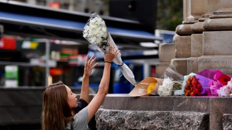 Passers-by lay flowers at the scene of yesterday's Bourke Street Mall tragedy.