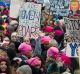 Women with bright pink hats and signs begin to gather early in Washington for the anti-Trump protest.