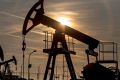 The sun sets beyond oil pumping units, also known as nodding donkeys or pump jacks, at an oil plant in the Czech Republic.