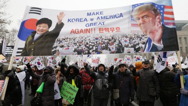 Supporters of South Korean President Park Geun-hye wave flags during a rally in Seoul on Saturday, opposing Park's ...