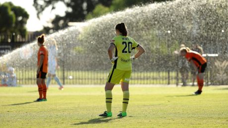 Players look on after sprinklers were turned on during the W-League match between Melbourne City and Brisbane Roar in ...