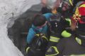 Italian firefighters extract a child from under snow and debris at Rigopiano.