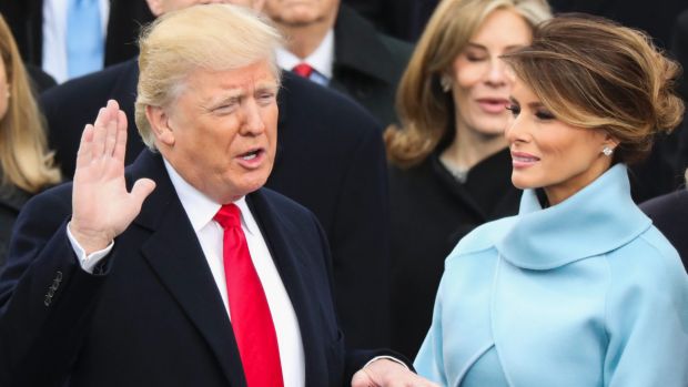 Donald Trump, watched by his wife Melania, is sworn in as the 45th president of the United States.