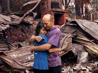 Mark & Rosemary Sims stand amid gutted ruins of home Mount View Road, Ferny Creek, Dandenong Ranges 22/01/97, one of 40 homes destroyed in worst bushfires since 1983 Ash Wednesday fires, couple lost all possessions including wedding rings. Sims/Fam Victoria / Bushfires / Fires 1997