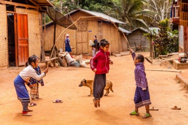 Girls the world over enjoy skipping. Here in a remote village in northern Laos they make do with a vine for their game.