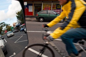 In view: a cyclist passes a parked car.