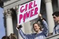 A girl holds banner as thousands of students march past the U.S. Capitol to protest President-elect Donald Trump in ...