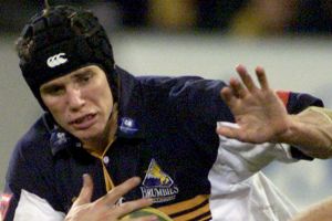 Brumbies great Stephan Larkham tries to palm off former Reds star Chris Latham in a Super Rugby semi-final in 2001.