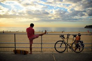 A man stretches his leg at Bondi beach before temperatures reach 38 degrees in the city today. Bondi Beach, Sydney. 11th ...