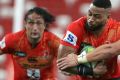 Andrew Durutalo (2R) of Sunwolves tries to evade a tackle.