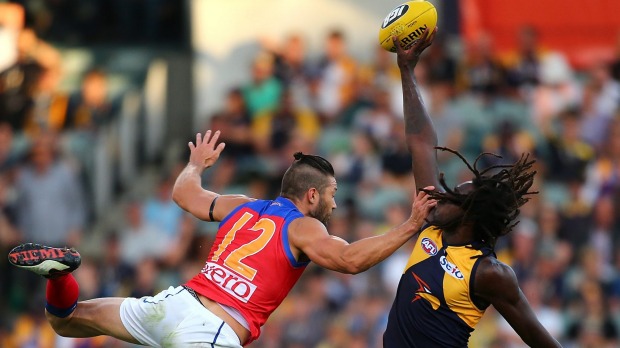 Tap out: Nic Naitanui wins a ruck contest against Brisbane's Stefan Martin.