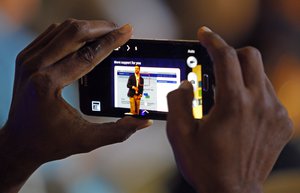 An attendee captures the keynote speech, on a mobile phone, from Facebook's director of small business Jonathan Czaja at Facebook's Boost Your Business Nashville event held at Marathon Music Works on Thursday, Aug. 27, 2015, in Nashville, Tenn.