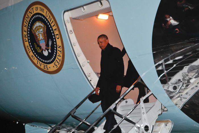 President Barack Obama steps off Air Force One at night. 