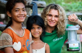 Danielle Cormack with young villagers in Cambodia and her favourite travel technology: a solar lamp.