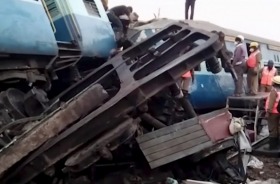 In this image from video, rescuers stand around coaches of a derailed passenger train in Kuneru, Andhra Pradesh, ...