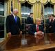 Vice President Mike Pence (left) watches as President Donald Trump prepares to sign his first executive order.