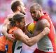 Lance Franklin tries to break the Callan Ward tackle.