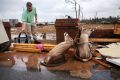 A man cleans up at at a home smashed by a tornado on January 22 in Adel, Georgia.