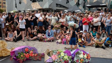 Mourners and flowers at Federation Square.