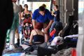 A mother and child pass the homeless people camp along Flinders Street. 