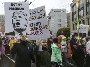 People walk along Market Street during a women's march during the first full day of Donald Trump's presidency in San Francisco, Saturday, Jan. 21, 2017.