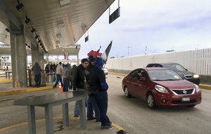 Protesters in Tijuana, Mexico, wave through motorists at the Otay Mesa Port of Entry with San Diego, Calif., after Mexican authorities abandoned their posts on Sunday, Jan. 22, 2017.