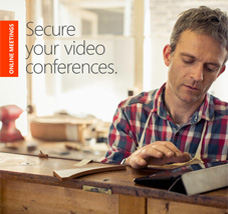 Man in a workshop looking at a tablet computer, get the Secure your video conferences eBook