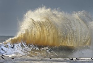 Surfers enjoy the large waves at the entrance to Santa Barbara, Calif., harbor Saturday morning, Jan. 21, 2017. A winter storm is bringing much higher than usual waves to the area.