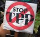 A protester holds signs against the Trans Pacific Partnership during a rally in Lima, Peru, last year.