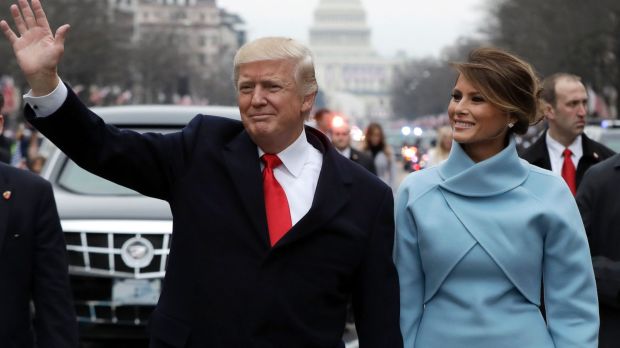 President Donald Trump waves as he walks with first lady Melania Trump during the inauguration parade.