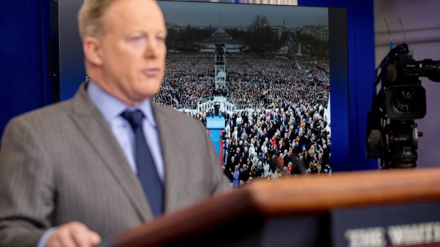 An image of the inauguration of President Donald Trump is displayed behind White House press secretary Sean Spicer as he ...