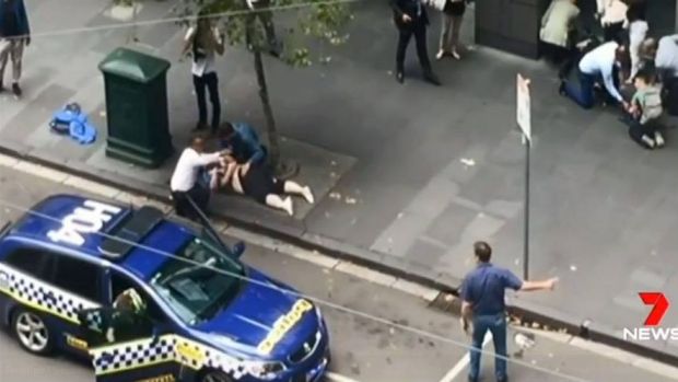 An image of Henry Dow and the taxi driver known as 'Lou' caring for a victim of the Bourke Street attack on Friday.