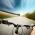 A photo of a rider driving bicycle on an asphalt road. Background is motion blurred.