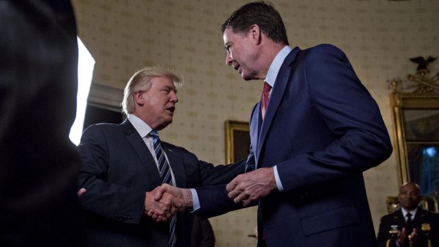 President Donald Trump greets James Comey during a reception at the White House on January 22.