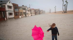 Isabella Busse , 6, walks through floodwater near the Seal Beach Pier during a storm in Seal Beach, Calif., Sunday, Jan. ...