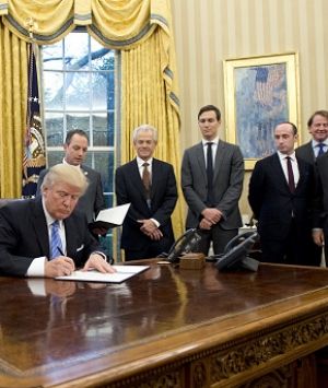 US President Donald Trump signs an executive order withdrawing from the Trans-Pacific Partnership.