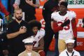 San Francisco 49ers quarterback Colin Kaepernick, middle, kneels during the national anthem before the team's NFL ...