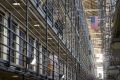 An inmate walks to his cell as corrections officers patrol at San Quentin Prison.