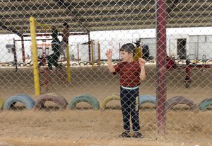 File - A young boy looks out from a covered playground at the Zaatari Refugee Camp, located near Mafraq, Jordan. The settlement has grown to house nearly 80,000 Syrian refugees since it opened in 2012.