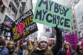 Demonstrators hold signs while marching towards Trump Tower during the Women's March in New York, U.S., on Saturday, ...