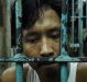 Wounded drug user Francisco Maneja, 27, sits in a cell at Manila Police Headquarters. 