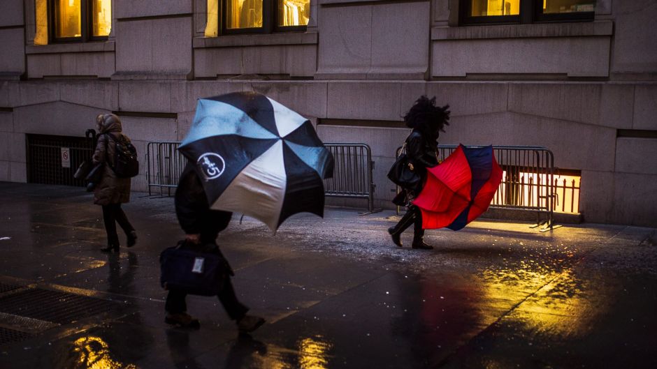 People walk against heavy wind in downtown New York, Monday, Jan. 23, 2017. From California to the Deep South to the ...